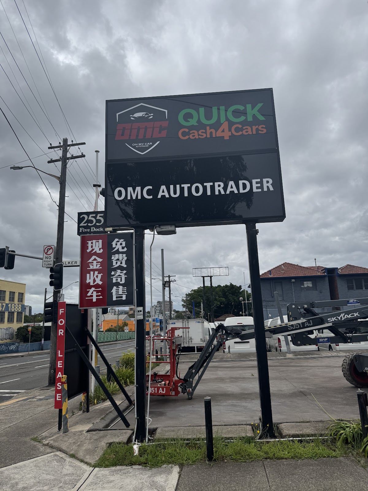 The street pylon at 255 Parramatta Road carrying the OMC Autotrader name and a QUICK Cash4Cars panel